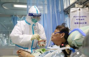 Nurse in a protective suit feeds a novel coronavirus patient inside an isolated ward at Zhongnan Hospital of Wuhan University